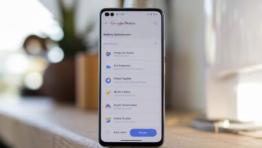 Smartphone affichant l'application Google Photos avec les paramètres d'optimisation de la batterie.