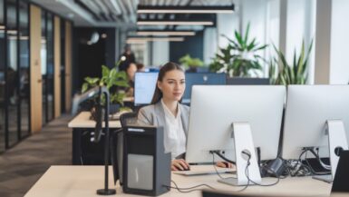 Jeune femme professionnelle dans un bureau moderne avec technologies IA
